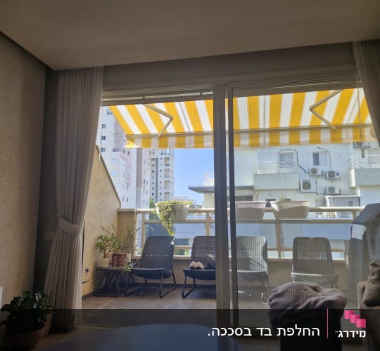 סוכך פסים צהוב ולבן במרפסת